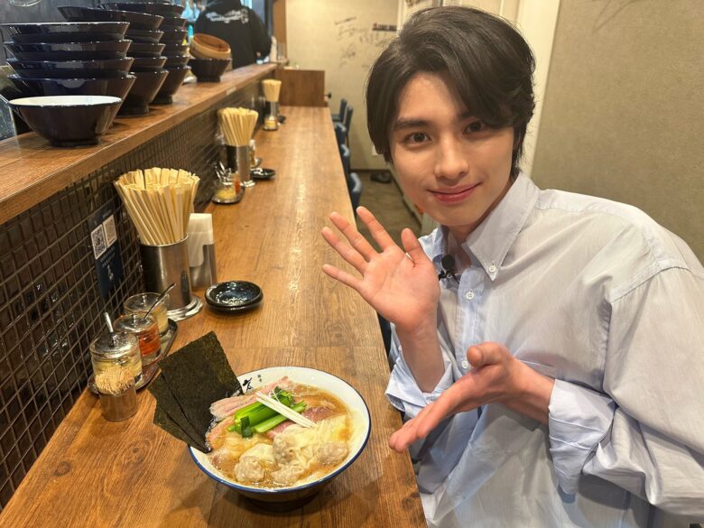 ラーメンを前に写真をとる本田響矢さん